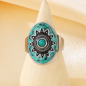 Macro detail of vintage bohemian turquoise ring with sun pattern on a wooden stand
