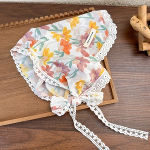 Detailed close-up of blue floral lace headscarf on wooden tray with cotton tag detail
