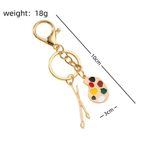 Macro shot of 10cm gold artist palette keychain with colorful enamel and brush charm