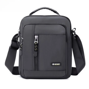 Detail view of water-resistant gray crossbody bag with sport logo and padded top handle