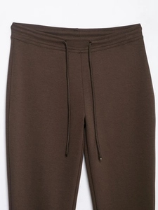 Detailed macro view of the elastic waistband and drawstring on dark brown casual pants