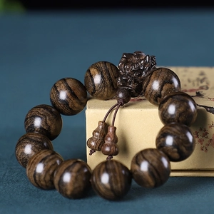 Vue détaillée du bracelet en bois d'agar avec motif tigre et pendentif tête de dragon