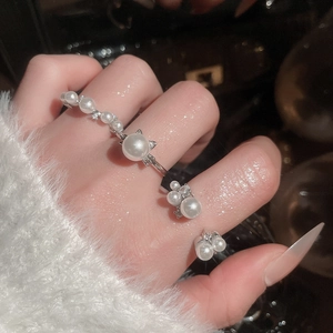 Close-up of elegant silver open rings with pearls and zircon on model finger