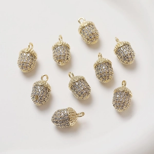 Detailed view of 14K gold-plated acorn pendants with sparkling pavé crystals for jewelry