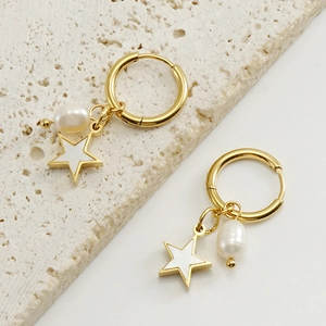 Détail de créoles en acier doré 18K avec pendentifs étoile et perle nacre