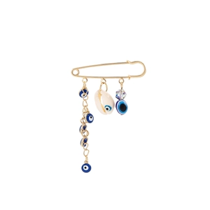 Macro shot of gold safety pin brooch with blue evil eye beads and shell pendant details