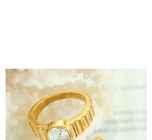 Detailed close-up of a gold-plated ring with a large oval zircon and ribbed metal texture