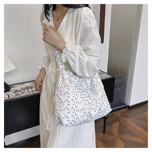 Close-up of floral canvas shoulder bag worn by model in a minimalist home setting