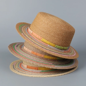Macro shot showing woven natural raffia texture and colorful fiber stitch details on sun hats