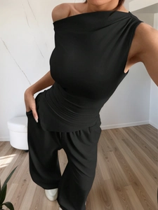 Detail of black one-shoulder sleeveless top and wide-leg trousers set with woven texture