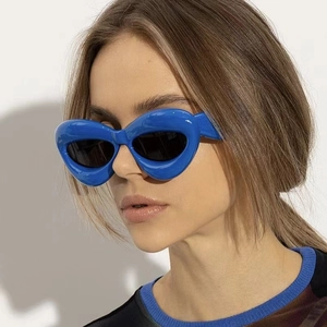 Close-up of inflated blue cat eye frame sunglasses with dark lenses on a model