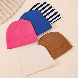 Five pack of soft knitted cotton baby beanies in various solid colors and stripes