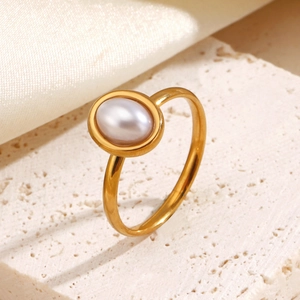 Elegant gold oval pearl ring on travertine stone background with silk fabric accents
