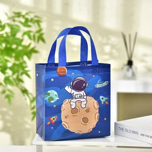 Dunkelblaue Vlies-Geschenktasche mit Astronauten-Motiv auf weißem Regal platziert