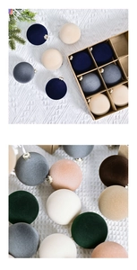 Gros plan de boules de Noël en velours de 6 cm en couleurs assorties sur tricot blanc