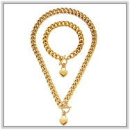 Close-up of golden Cuban chain jewelry set with heart pendants and T-bar clasps