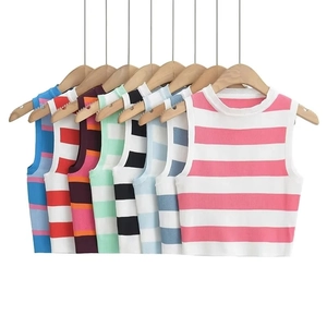 Detail of colorful knitted striped crop tops in pink, blue, and green on wooden hangers