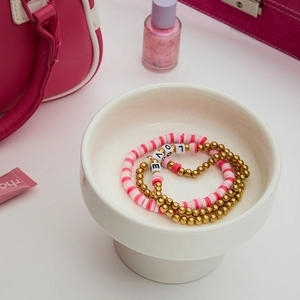 Detailliertes Set aus drei Freundschaftsarmbändern mit rosa Tonperlen und Goldakzenten
