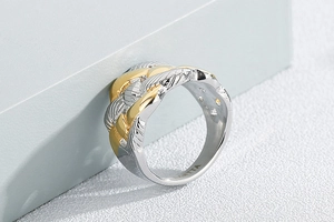 Detailed shot of two-tone braided texture stainless steel ring with gold accents
