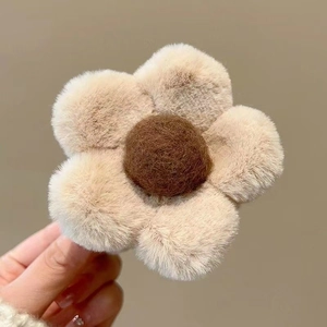 Detail of plush beige and brown floral hair clip with soft faux fur texture for winter