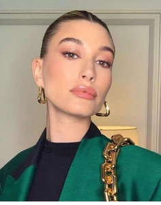 Close-up of stylish geometric U-shaped twisted metal earrings on a fashion model