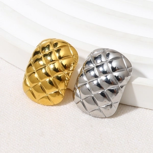 Detailed view of gold and silver stainless steel rings with a quilted diamond texture