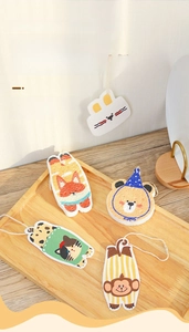 Thick animal-shaped wood pulp sponge wipes on a wooden tray for kitchen cleaning