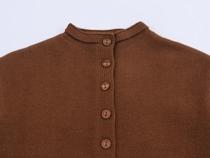 Detail of round neckline and matching buttons on a dark brown knitted cardigan