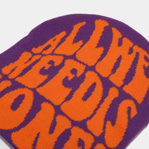Detailed close-up of Y2K knit beanie featuring purple and orange jacquard lettering