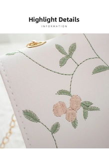 Detailed embroidery on white leather bag with floral patterns and gold metal ring