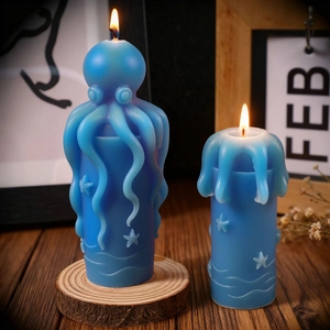 Detailed view of two blue octopus pillar candles with starfish and wave textures