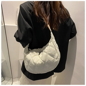 Beige quilted nylon crescent shoulder bag shown on model with chic oversized design
