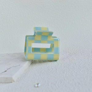 Detail of a square claw clip with yellow and blue checkered pattern in acetate material