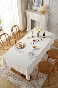 Close-up of white washed cotton tablecloth featuring delicate lace borders and texture