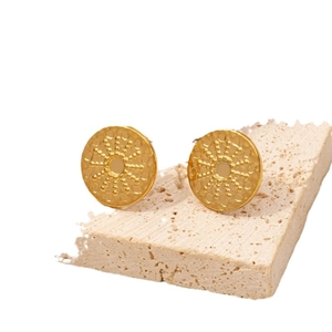 Minimalist 304 stainless steel sunburst gold stud earrings on travertine stone base
