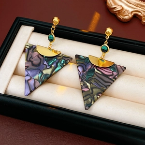 Macro detail of vintage triangle earrings with colorful shell inlay and green gem accents