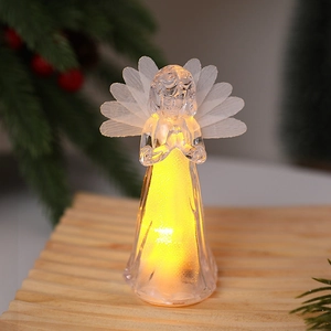 Detail of transparent LED angel statue with mesh wings on wooden desk with Christmas tree
