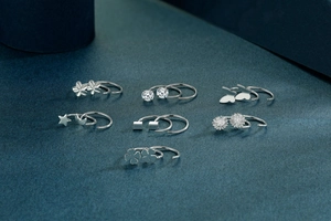 Detailed set of seven sterling silver stud earrings with floral and geometric designs