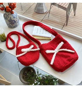 Detail of red plush fleece bucket bags with white knit bows in a cozy tea scene
