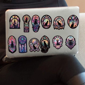 12 gothic stained glass black cat stickers on a laptop lid with floral and moon motifs
