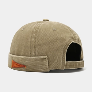 Détail du bonnet docker avec étiquette orange Music Club et texture en coton lavé