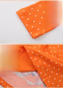 Detail view of smooth orange polka dot fabric with precise stitching on cuffs and hemline