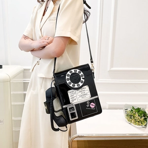 Detail of vintage telephone handbag in black patent leather with realistic handset