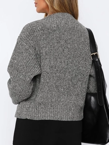 Detail view of the gray chunky knit sweater back and shoulder seam on female model