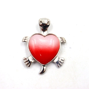 Detail van een zilveren schildpad hanger met een hartvormig roze kristal in kleurverloop