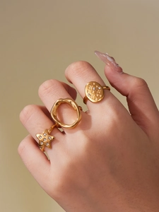 Detailed view of three 18k gold plated rings featuring stars and zircon inlays on model hand