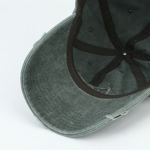 Faded grey-green vintage washed baseball cap with distressed brim and metal rivet detail