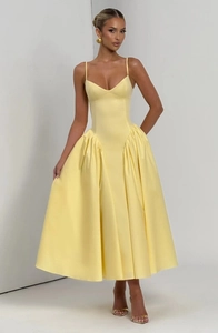 Détail de la robe longue en satin jaune montrant la taille plissée et le tissu brillant