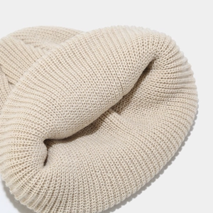 Close-up of cream white ribbed knit beanie showing thick wool blend texture and detail