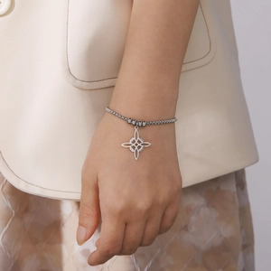 Bracciale a sfere in acciaio argento con pendente a nodo di strega cavo indossato al polso